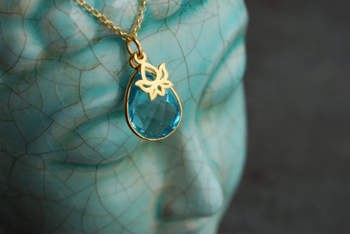 NAMASTE . Vergoldete Kette mit Edelstein-Tropfen Blauer Topas und Lotus-Anhänger