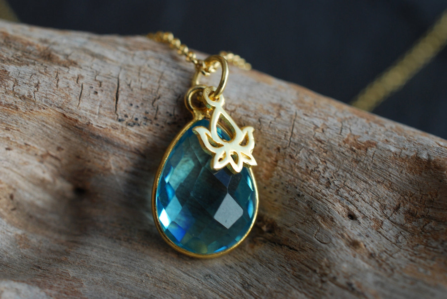 NAMASTE . Vergoldete Kette mit Edelstein-Tropfen Blauer Topas und Lotus-Anhänger