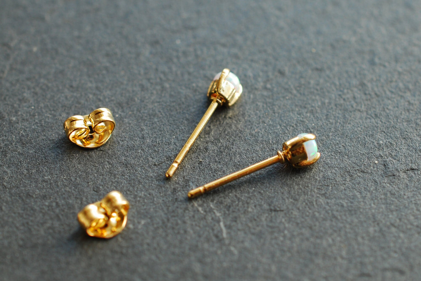 Winzige Ohrstecker . 18k vergoldete Ohrringe mit synthetischen Opal-Steinchen