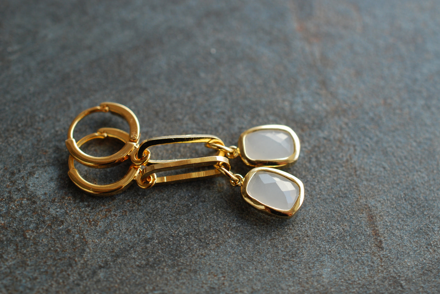 CLIO . Lange, vergoldete Ohrringe mit Glas-Steinen in der Farbe Rauchglas